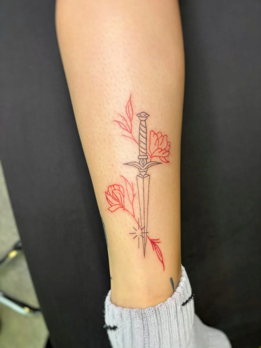 Dolch mit roten Rosen als Fineline Tattoo am Bein