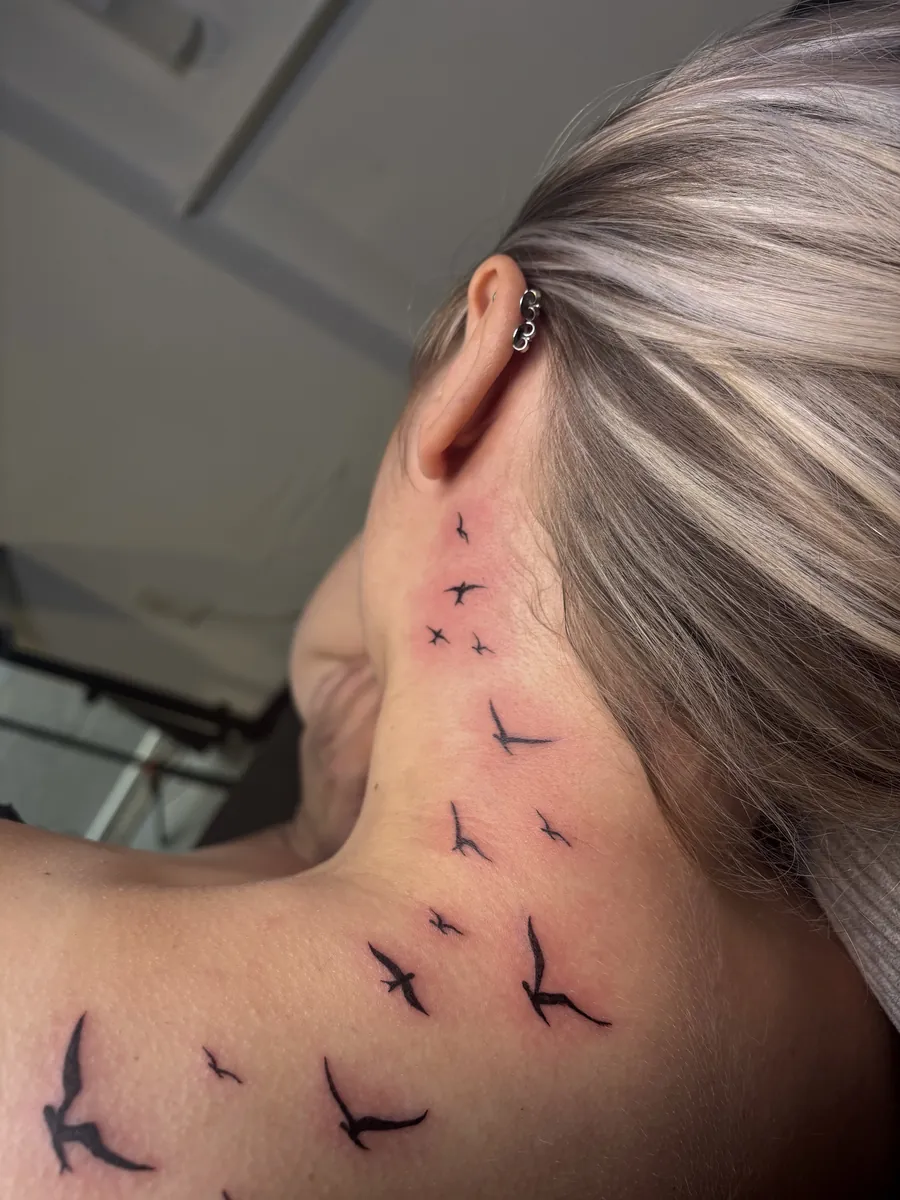 Fliegende Vögel als Fineline Tattoo am Hals